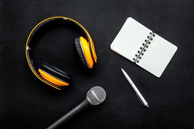 podcast record with notebook, microphone and headphones on black background top view space for text