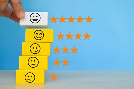 Wooden cube blocks with different face emotion. Customer evaluation and satisfaction concept.