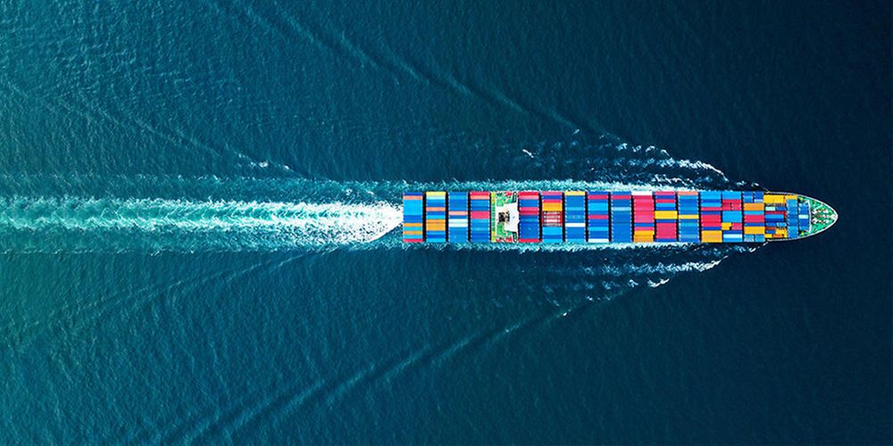 Ein Containerschiff f&auml;hrt &uuml;ber das Meer