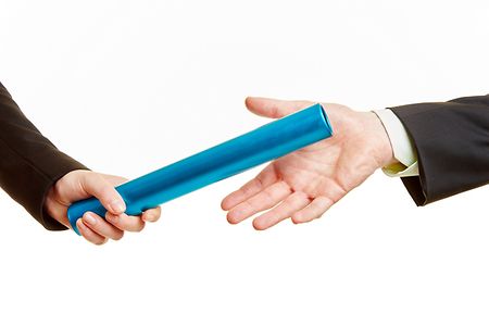 Zwei H&auml;nde bei der &Uuml;bergabe eines Staffelstab 