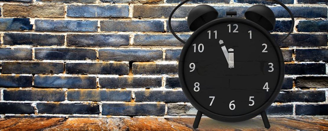 Wecker vor einer Mauer