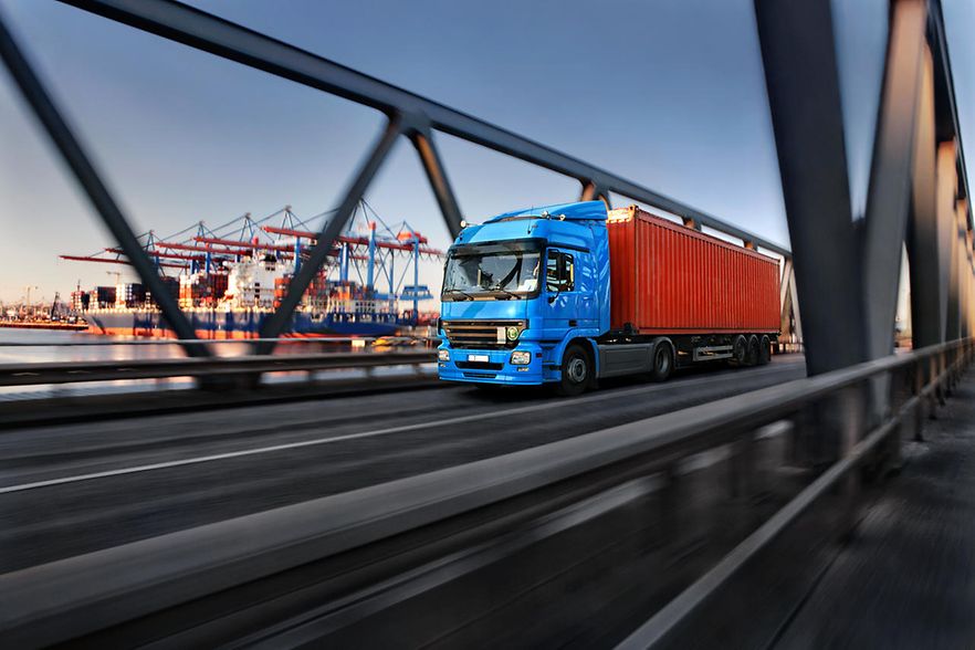 LKW &uuml;berquert Br&uuml;cke, Lastkr&auml;ne im Hintergrund