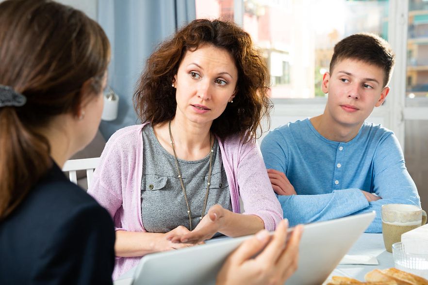Mutter und Sohn mit einer Beraterin