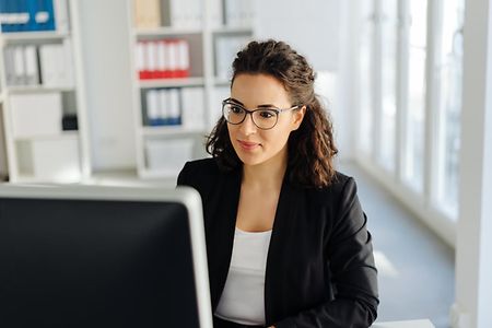 Woman smiling to herself as she works in an office