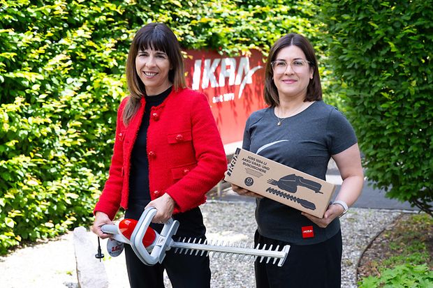 Maria Farruggio-Eiselt und Miriam Garcia mit Akku-Scheren vor einer Hecke