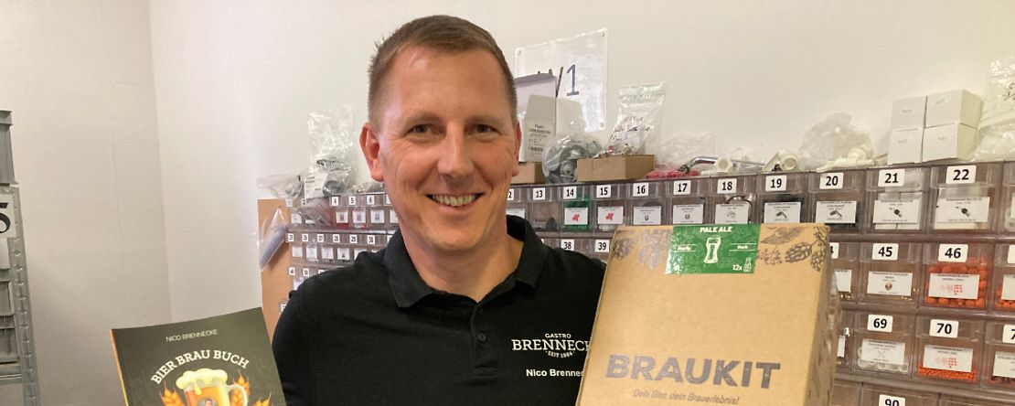 Firmeninhaber Nico Brennecke mit seinem Bier Brau Buch und einem Braukit.