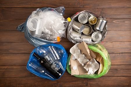 Recycling and ecology concept. Sorting household waste - plastic, paper, metal, captured from above, flat lay. Wooden background
