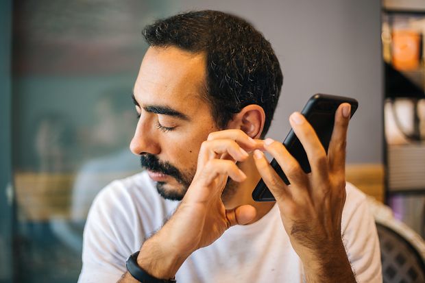 Blinder Mann nutzt Mobiltelefon