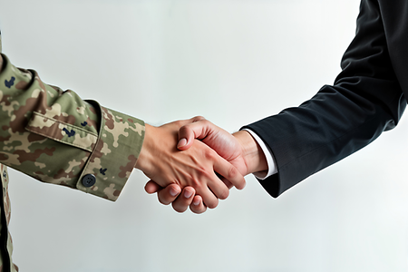 Soldat und Zivilist sch&uuml;tteln sich die H&auml;nde