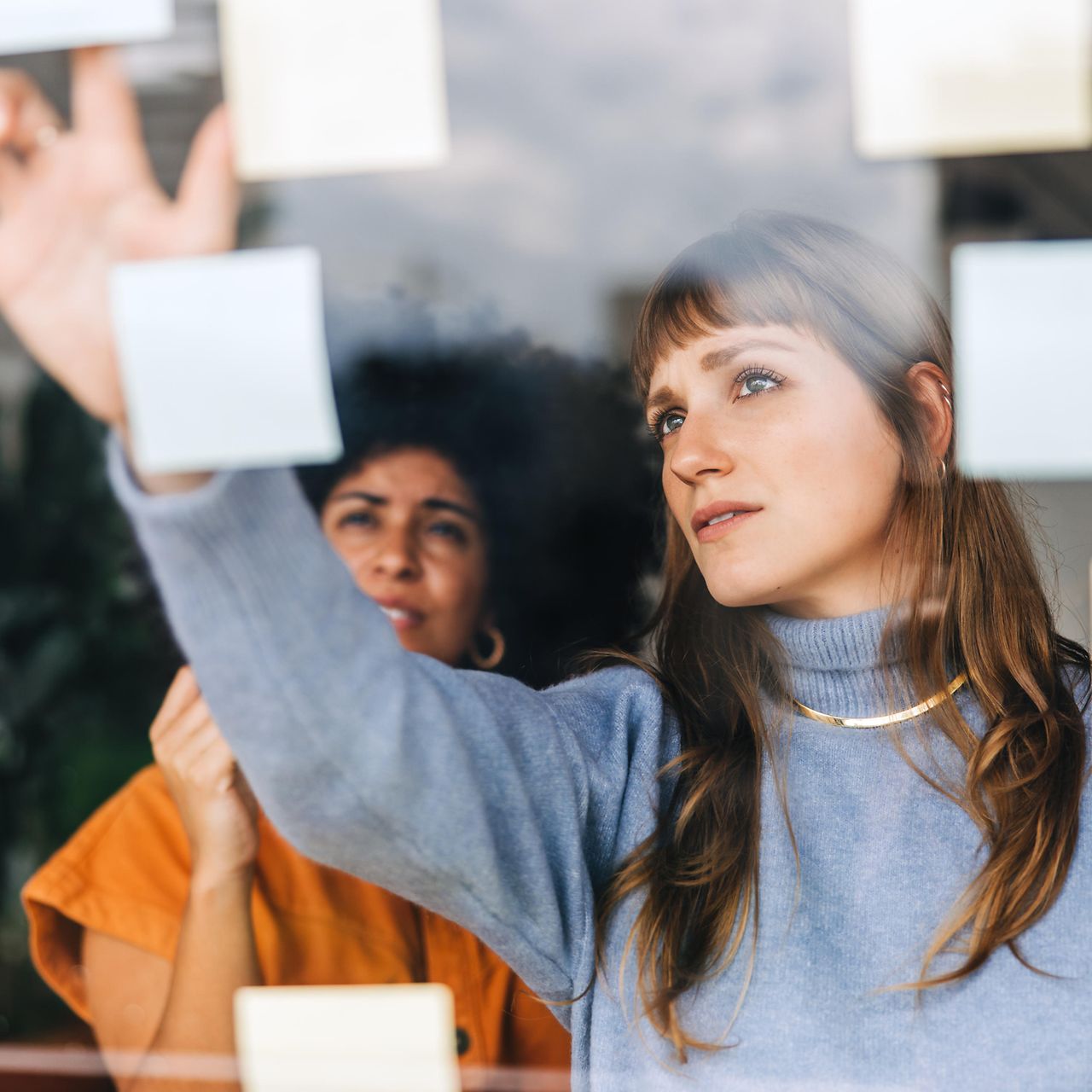 Businesswomen brainstorming using adhesive notes