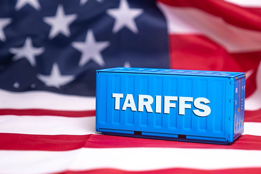 Kleiner Container mit der Aufschrift Tariffs steht auf amerikanischer Flagge