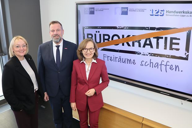Hauptgesch&auml;ftsf&uuml;hrende der drei Kammern vor Bildschirm mit durchgestrichenem &bdquo;B&uuml;rokratie".