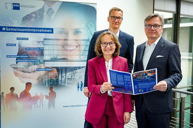 Akteure der IHK halten eine Brosch&uuml;re mit den aktuellen Ergebnissen der Konjunkturumfrage in die Kamera.