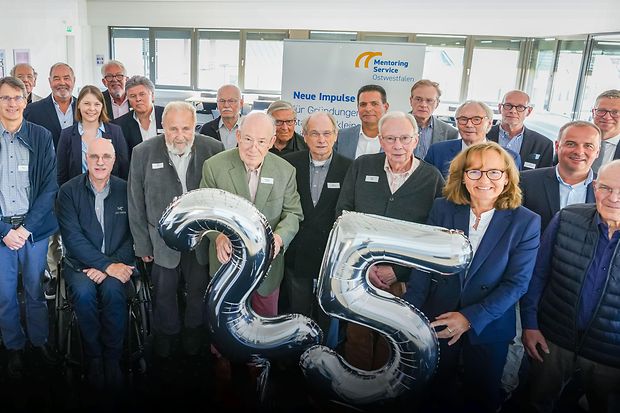Gruppenfoto zum 25-j&auml;hrigen Jubil&auml;um des Mentoring Service Ostwestfalen, mit silbernen &bdquo;25&ldquo;-Ballons.