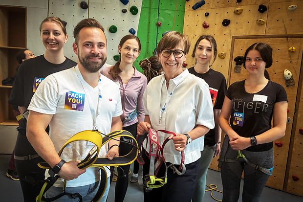Gruppe junger Menschen mit Klettergurten vor Kletterwand, alle tragen &bdquo;Fach You!&ldquo;-Sticker der IHK-Kampagne