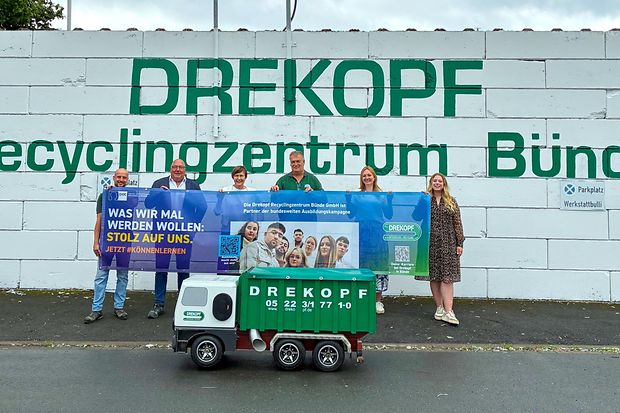 Gruppenfoto mit Banner vor dem Drekopf Recyclingzentrum B&uuml;nde.