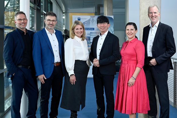 Sechs Personen stehen in Businesskleidung f&uuml;r ein Gruppenfoto im IHK-Geb&auml;ude.