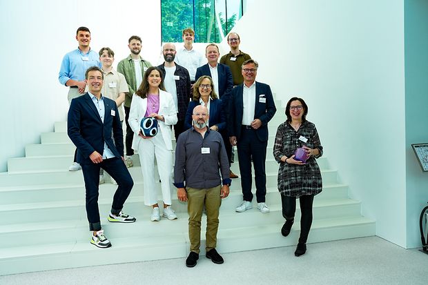 Gruppenfoto auf Treppe: Teilnehmende der Ausbildungstour stehen auf einer wei&szlig;en Treppe f&uuml;r ein Gruppenbild.