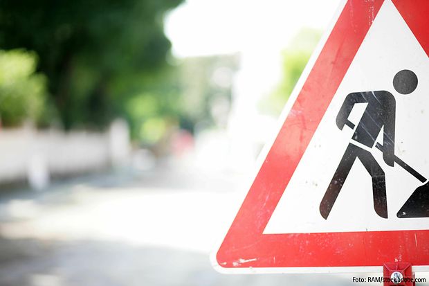 Nahaufnahme eines Verkehrszeichens &bdquo;Baustelle&ldquo; mit verschwommenem Hintergrund.