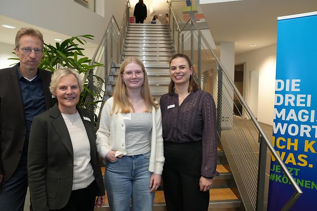 Gruppenfoto: Drei IHK-Vertreter stehen mit einer Ausbildungsbotschafterin aus dem Kreis Herford auf einer Treppe