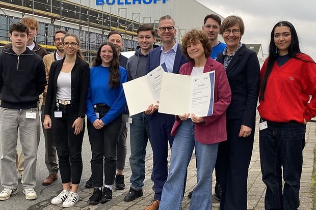 Gruppenfoto mit Urkunden vor dem B&ouml;llhoff-Geb&auml;ude.