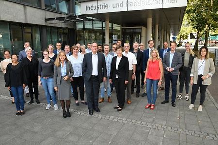 Gruppe von Personen vor dem IHK-Geb&auml;ude in Bielefeld, drau&szlig;en auf dem Gehweg