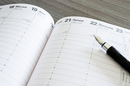 Aufgeschlagener Terminplaner mit Stift