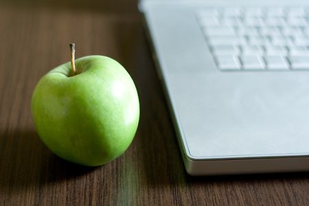 Gr&uuml;ner Apfel neben einer Laptop-Tastatur