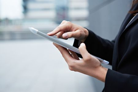 Gesch&auml;ftsfrau bedient Tablet-PC