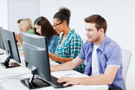 IT-Studenten sitzen in einer Reihe und arbeiten an Computern