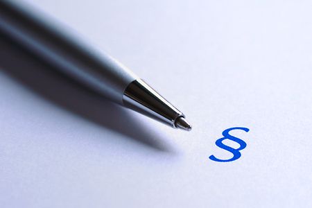 Stift und blaues Paragrafenzeichen auf wei&szlig;er Unterlage