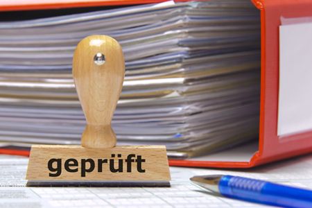 Aktenordner, Stift und Stempel mit Aufschrift gepr&uuml;ft