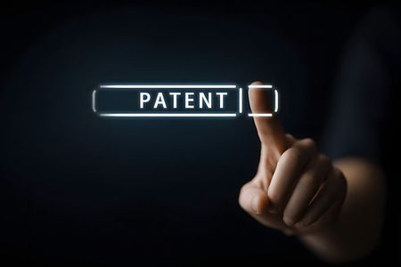 Hand tippt auf virtuelles Feld mit dem Wort &bdquo;Patent&ldquo;