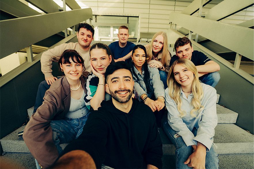 Gruppenselfie der Kampagnen-Creator auf einer Treppe