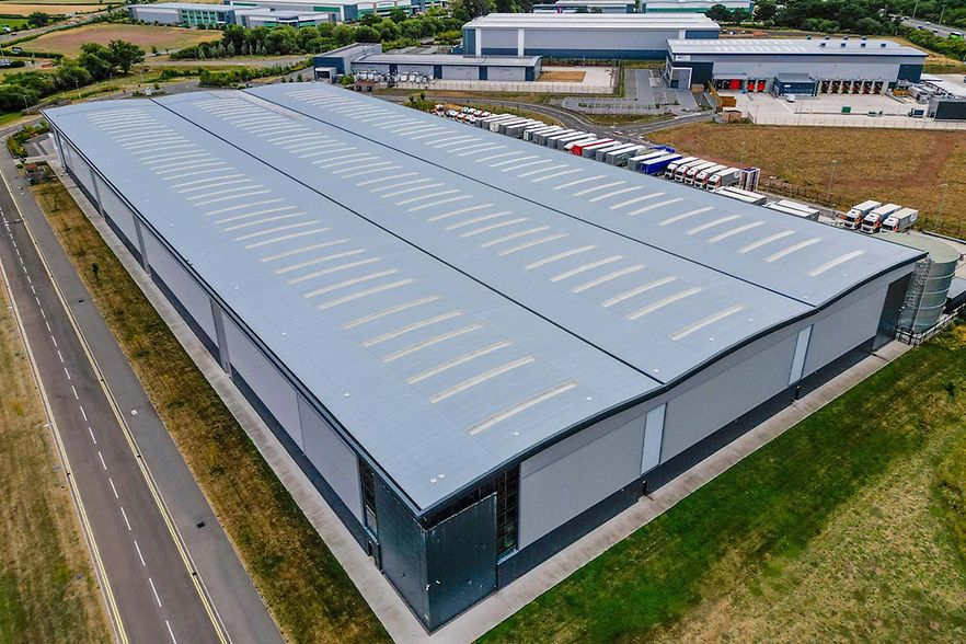 Luftaufnahme einer gro&szlig;en Gewerbehalle mit angrenzenden LKW-Stellpl&auml;tzen