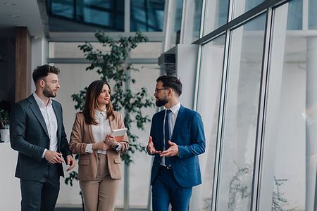Businesspeople walking and talking in modern office