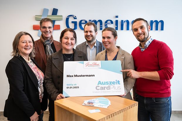 Mehrere Menschen pr&auml;sentieren die AuszeitPlusCard