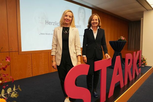 Zwei Frauen stehen auf B&uuml;hne neben roten Buchstaben &sbquo;STARK!&lsquo;