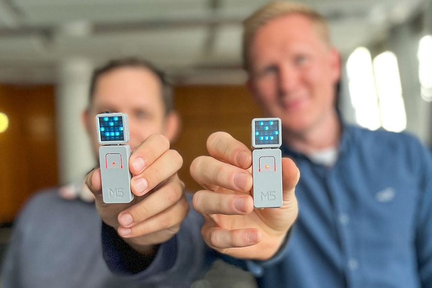 Zwei M&auml;nner halten digitale Ger&auml;te in die Kamera