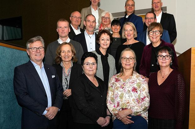 Gruppenfoto mehrerer Personen bei einer Veranstaltung auf einer Treppe.