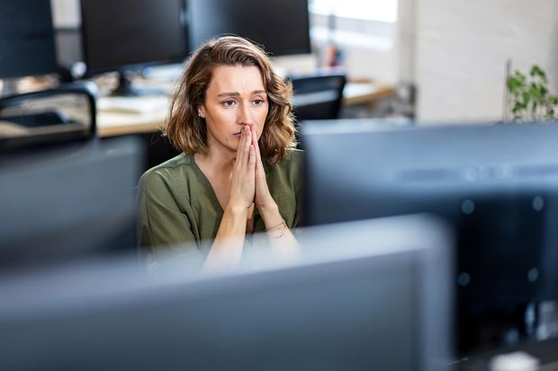 Stressed businesswoman sitting in front of desktop at office