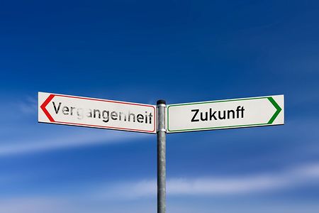 Wegweiser &bdquo;Vergangenheit&ldquo; und &bdquo;Zukunft&ldquo; vor blauem Himmel.