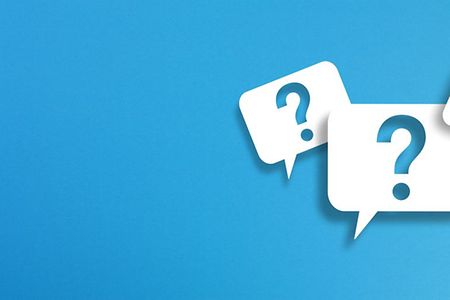 Wei&szlig;e Sprechblasen mit Fragezeichen auf blauem Hintergrund.