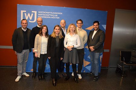 Wirtschaftsjunioren Paderborn-H&ouml;xter vor Pressewand.