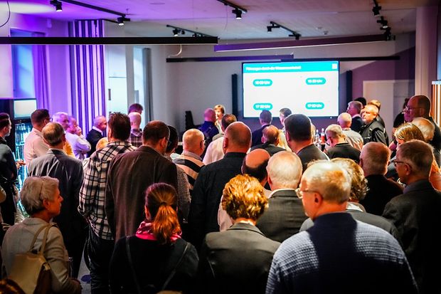 Gro&szlig;e Zuh&ouml;rerschaft bei einer IHK-Veranstaltung mit Pr&auml;sentation im Hintergrund.
