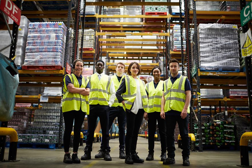 Group portrait of staff at distribution warehouse, low angle