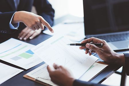 Close up view of business people discussing the charts and graphs showing the results of their successful teamwork.