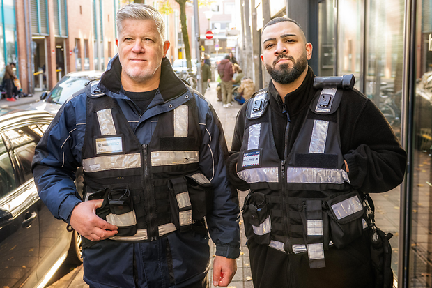 Zwei Security-M&auml;nner stehen in einer Stra&szlig;e