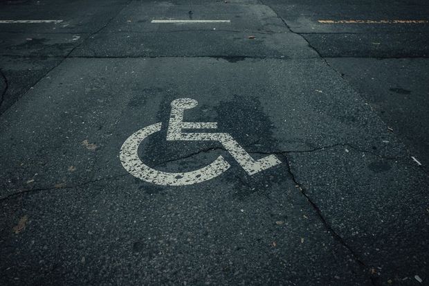 Rollstuhlsymbol auf rissigem Asphalt