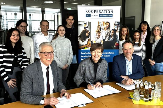 Unterzeichnung: IHK-Schule-Wirtschaft, Gruppe Jugendlicher im Hintergrund